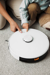 Parent and son examine together new robotic vacuum cleaner