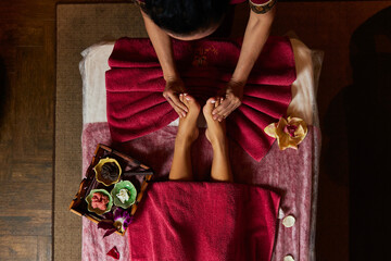 Beautician does feet massage for woman visitor in resort