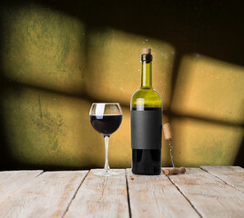 Excellent red wine bottles, wineglass, barrel and corkscrew on a rustic wooden table: traditional winemaking and wine tasting concept. High quality photo