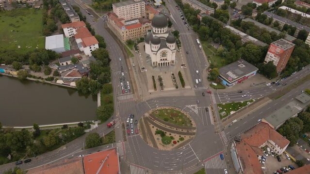 Aerial video shot from a drone while flying forward and lowering altitude. In the footage can be seen the orthodox cathedral in Arad city, Romania and a busy intersection.