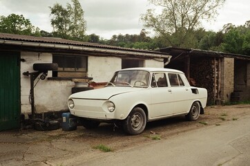 Old car in front of an abandoned house