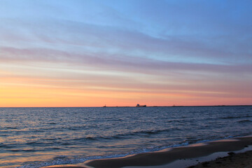 Colourful sunsetting sky above dark sea. Selective focus