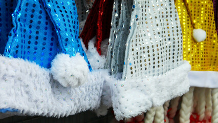 Close-up of many colorful Christmas hats on a store rack