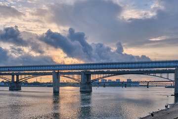 Fototapeta na wymiar Novosibirsk Metro Bridge over Ob River in Novosibirsk, Russia. Cityscape on sunset