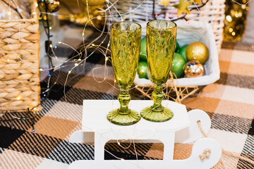 Glasses of sparkling champagne near the Christmas tree, garland and Christmas decoration. Christmas and New Year celebrations.