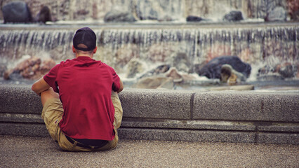 A man sitting by fountain