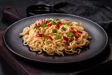 Delicious fresh noodles with sweet pepper, tomato, spices and herbs