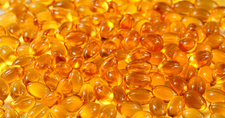 Fish Oil Capsules Surface. Healthy Background and Medicine Concept. Omega 3 Natural Fat in Healthy Lifestyle and Sport Dieting. Yellow Pills with Cod Liver Oil Medicines