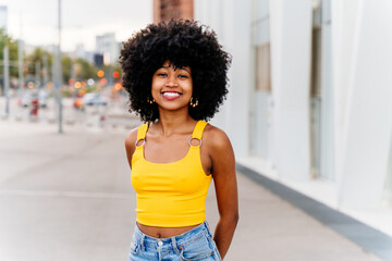 Fototapeta na wymiar Beautiful young black woman outdoors in the city - Afro american cheerful female adult portrait