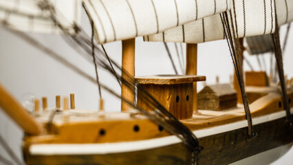 Model of a wooden ship with three masts isolated on a white background.