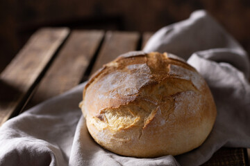 Homemade bread and cloth napkin at table. Bakery concept on wood tabletop