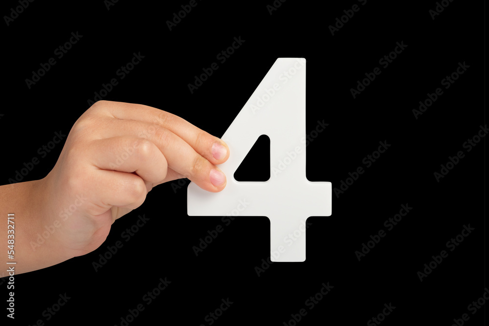 Poster number four in hand isolated on black background. number four in a child's hand, holding on a black 