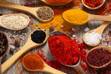 Variety of spices in spoon at table background. Cooking concept and ingredients on kitchen