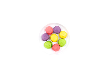 Colored macaroons on a plate. On a white background.