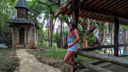 Mulher passeando em lindo sítio com varandas de madeira, construido na lagoa Várzea das Flores em...