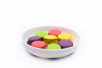 Colored macaroons on a plate. On a white background.