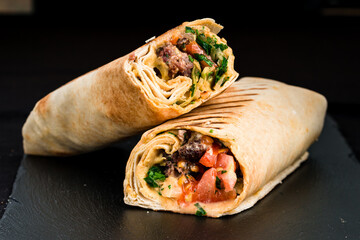 Shawarma from beef, tomatoes, greens, sauce and pita bread.