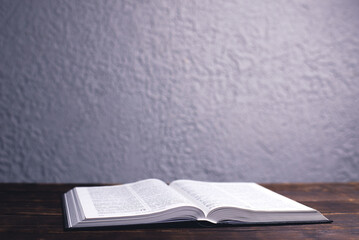 An open Bible on the table. Holy Scripture on a wooden background. Prayer to pray
