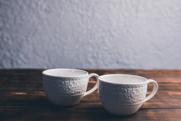 Cups of coffee on the table. White cups on a wooden background