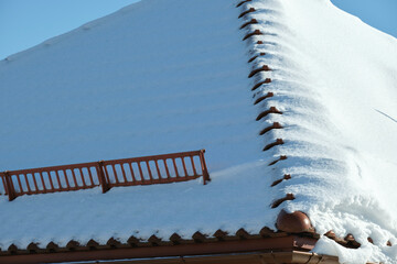 Snow guard for safety in winter on house roof top covered with steel shingles. Tiled covering of...
