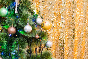 Obraz na płótnie Canvas Decorated Christmas tree with balls and garland and bright bokeh background, copy space background