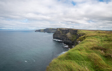 Fototapeta na wymiar Spectacular view of famous Cliffs of Moher and wild Atlantic Ocean, cloudy day, County Clare, Ireland.
