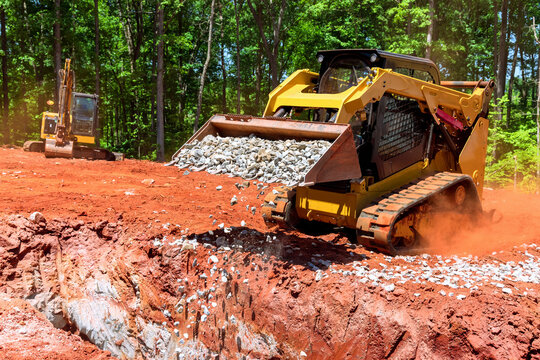 As Bobcat Mini Loader Is Delivering Crushed Stone To Drainage Pit It Falls Asleep