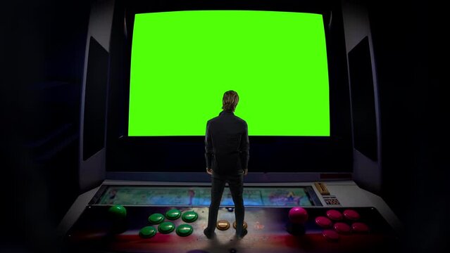 Retro Arcade Game Man Standing Old Console Green Screen. Man standing on top of an old arcade video game green screen. Surreal Scene