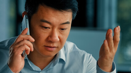 Dissatisfied male businessman client annoyed asian korean angry man talking mobile phone has...