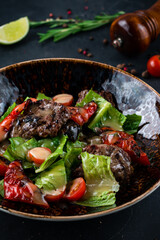 Tasty salad with beef medallions, roasted peppers, tomatoes, lettuce and dressing.