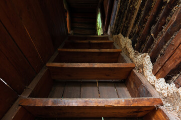 Fototapeta na wymiar Perspective view of an old wooden stairway going up