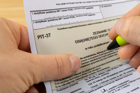 Pit 37 form, annual tax return form for individuals in Poland, Hand with a pen filling out a document for the tax office