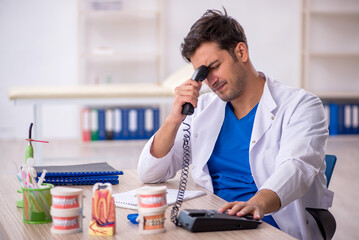 Young male dentist working in the clinic