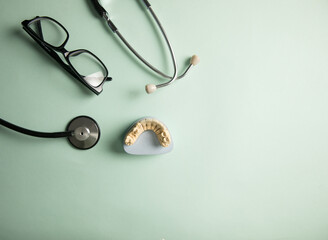 Stethoscope, teeth mockup and glasses on the table