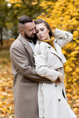 Happy family, beautiful couple on a fall picnic in the park, surprise date. Cozy autumn vibes, bright colours. Spending quality time together