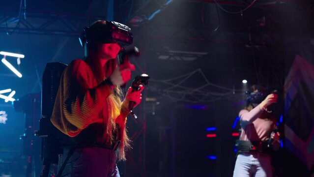 Woman playing VR games in a studio with blue pink neon lights
