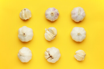 Fresh white unpeeled head bulb of garlic on yellow color background. Vegan, organic, vitamins. Natural antibiotic, antioxidant, Allicin. Top view. Flat lay