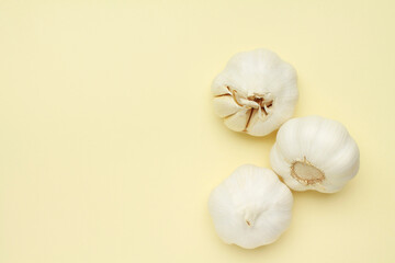 Obraz na płótnie Canvas Fresh white unpeeled head bulb of garlic on yellow color background. Vegan, organic, vitamins. Natural antibiotic, antioxidant, Allicin. Top view. Flat lay. Copy space for text