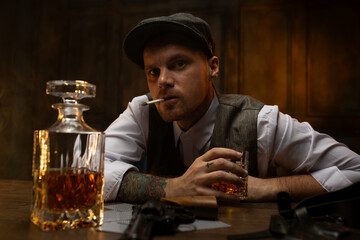 Cards and revolver lying on table in front of dissatisfied gangster