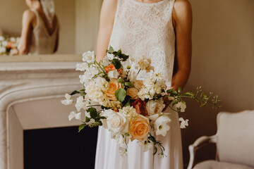 La mariée tenant son bouquet de fleurs et son reflet dans le miroir