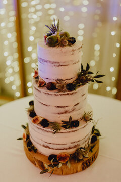 Gâteau de mariage devant un rideau lumineux