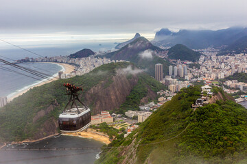 Cable car in the clouds on its way to the top of SugarLoaf, and city panorama of Rio de Janeiro,...