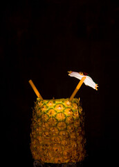 Exotic pineapple in the shape of a drink, with organic straw and mini umbrella