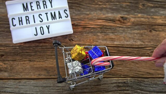 Close up from Santa Claus hand puling toy cart with gifts