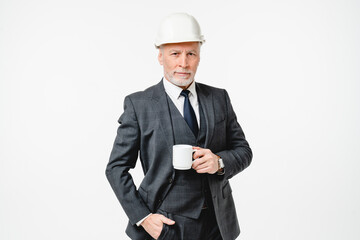 Middle-aged caucasian senior engineer architect construction worker in hardhat drinking coffee tea hot beverage isolated in white background