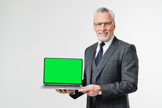 Happy confident caucasian middle-aged businessman ceo boss lawyer showing laptop screen with mockup copyspace for mobile online application isolated in white