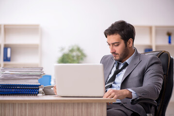 Young male employee and too much work in the office