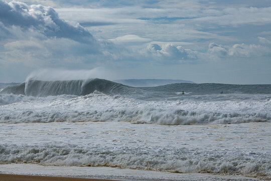 View of big waves and surfers from the beach