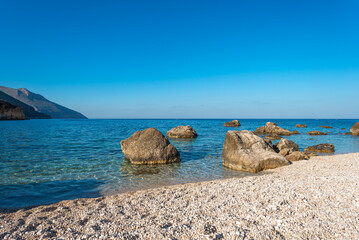Small pebble beach in a bay of the Gulf of Castellammare near the tourist resort and village of Scopello in northern Sicily. The beach is close to the Zingaro National Park.