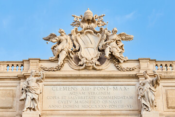 Obraz premium Trevi Fountain coat of arms with an inscription, Rome, Italy. Details of the papal coat of arms of Pope Clement XII on the top of Fontana di Trevi with crossed keys of Saint Peter.